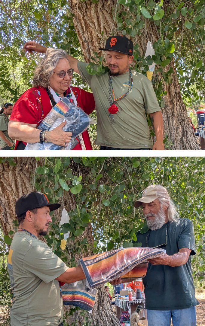 Festival organizer José Luis presents commemorative blankets to Dr. Ana Malinalli X Gutiérrez Sisneros and Don Bustos, honored as this year's Madrina del Ajo and Padrino del Ajo.